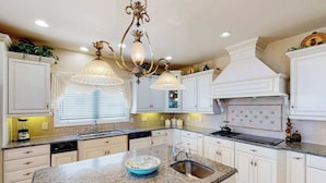 A kitchen with white cabinets, granite countertops, a central island, and pendant lighting. - Fantastic oceanfront home w/private pool & hot tub, WiFi, central AC, & deck (Virginia Beach)