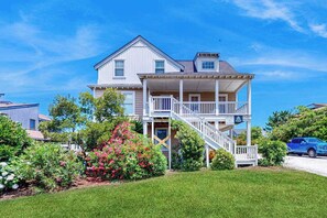 A two-story house with a front porch, a staircase, and a driveway. - Renovated ocean-side house with pool, putting green, volleyball & beach access (Virginia Beach)