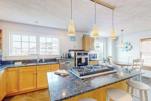 A modern kitchen with granite countertops, stainless steel appliances, and pendant lighting. - Renovated ocean-side house with pool, putting green, volleyball & beach access (Virginia Beach)