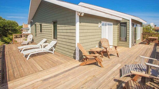 A wooden deck with lounge chairs and a small building with a sloped roof. - Hess affordable home w/easy walk to the beach, central AC, WiFi, & private W/D (Virginia Beach)