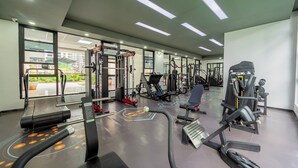 Et moderne fitnesscenter med forskellig træningsudstyr, store vinduer og et rent, veloplyst interiør.
