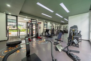 A modern gym with various exercise equipment, large windows, and a clean, well-lit interior. - Misty Springs 1BR near GTC - Heated Infinity Pool, Gym, Fast WiFi (Nairobi)