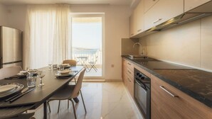 Una cocina moderna con comedor, vistas al exterior y un balcón.