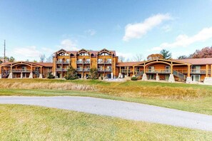 A multi-story hotel with balconies, a central courtyard, and a paved walkway.