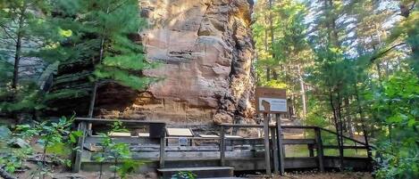 A natural rock formation with a wooden viewing platform and a sign.