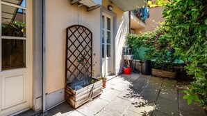 Ein Wohngebäude mit Balkon, einer Holz-Pflanzkasten und einer Topfpflanze.
