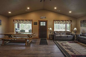 Un salón espacioso con una mesa de madera, un sofá y una alfombra.