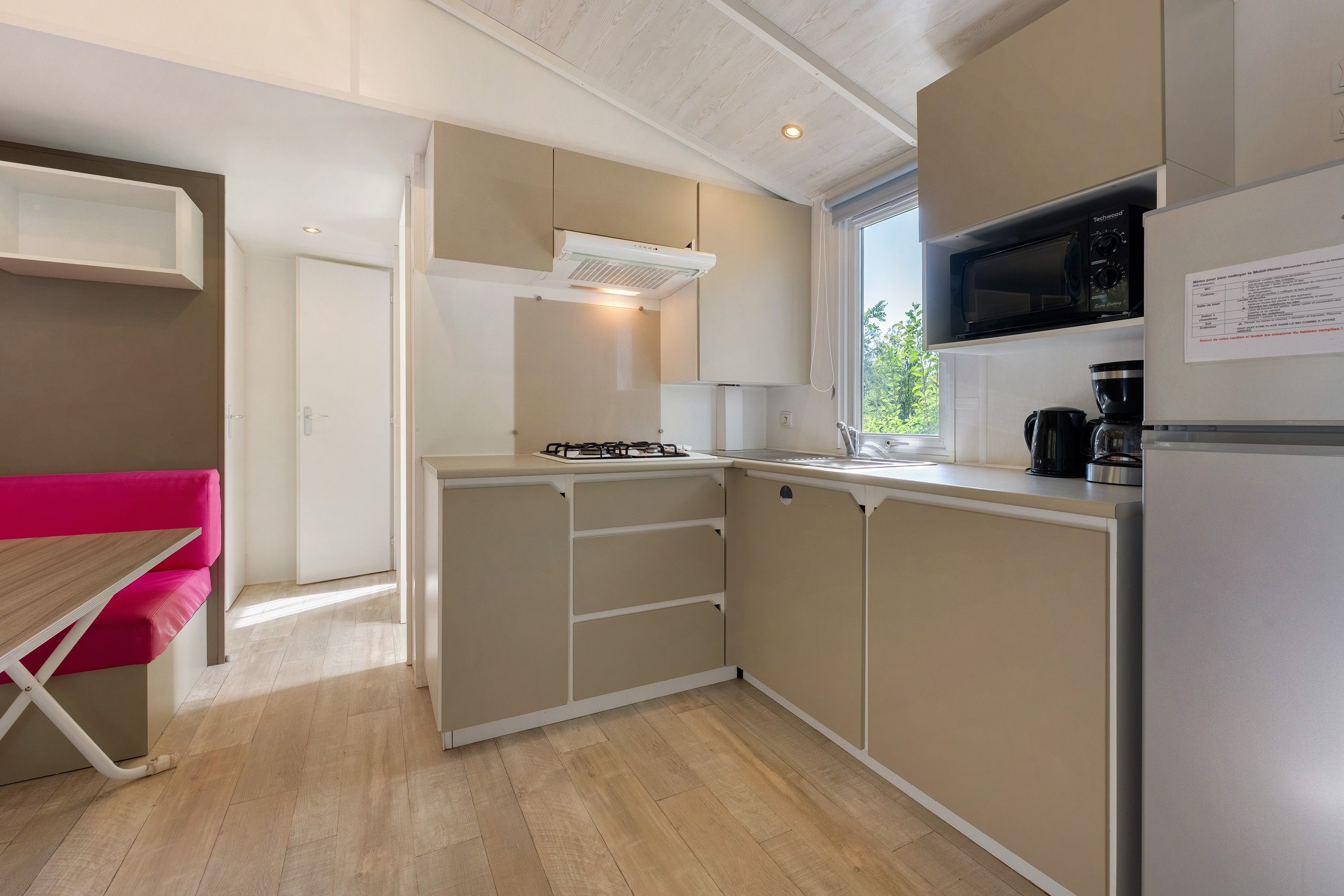 A compact kitchen with a gas stove, a microwave, and a coffee maker.