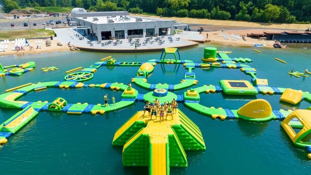 Luftaufnahme eines Wasserparks mit verschiedenen aufblasbaren Spielgeräten.