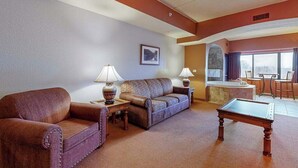 Ein Wohnzimmer mit einer Couch, zwei Lampen, einem Couchtisch und Blick zur Küche.