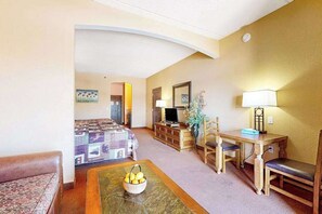 Ein Hotelzimmer mit Bett, Schreibtisch, Stuhl, Fernseher und Lampe.