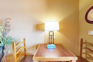 Ein Holztisch mit einer Lampe, zwei Stühlen und einer Topfpflanze.