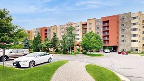 Un hotel con patio central, estacionamiento y un edificio de varios pisos y balcones.