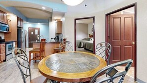 Una cocina moderna con comedor, microondas, refrigerador y una mesa redonda con sillas.