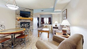 Una sala de estar con chimenea, una mesa de comedor y un sofá.