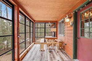 Una habitación con paneles de madera, ventanas amplias, un banco de madera y una mesa.