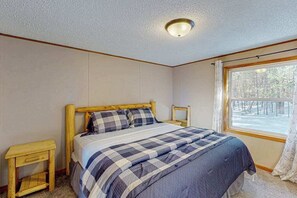 Una camera da letto con un letto, una finestra e una lampada a sospensione.