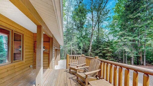 Eine Holzterrasse mit Sitzgelegenheiten, umgeben von Wald.