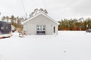 A small, single-story building with a gabled roof, a front door, and a window. - Dog-friendly, tree-lined home on the snowmobile trail with streaming, W/D, & AC (Manitowish Waters)