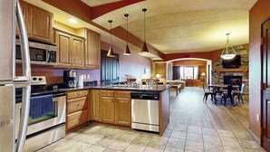 A spacious kitchen with wooden cabinets, stainless steel appliances, and a central island. - Wisconsin Dells Escape | Adventure Perks Included (Wisconsin Dells)
