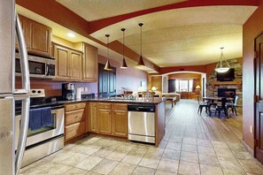 A spacious kitchen with wooden cabinets, stainless steel appliances, and a central island. - Wisconsin Dells Escape | Adventure Perks Included (Wisconsin Dells)