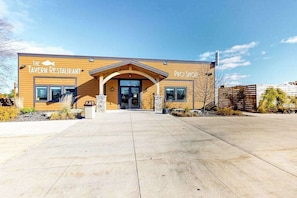 A building with a sign reading 'The Tavern Restaurant' and 'Pro Shop' on the side. - Wisconsin Dells Escape | Adventure Perks Included (Wisconsin Dells)
