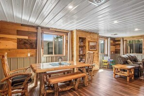 A wooden interior with a dining table, chairs, a sofa, and a bookshelf. - Inviting home with game room, firepit, full kitchen, & W/D (Arkdale)