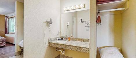 A bathroom with a sink, mirror, and towel rack.