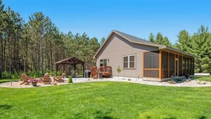 Une maison de plain-pied dotée d’un patio couvert, d’une petite terrasse et d’une pelouse bien entretenue.