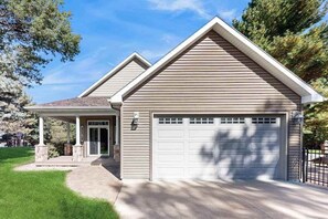 A residential house with a garage, a covered entryway, and a well-maintained lawn. - Stunning home w/ hot tub, wet bar, theater room, pool table, near golf & lakes (Arkdale)