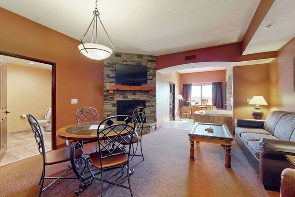 A hotel room with a dining area, a living room, a fireplace, and a television. - Spacious Condo Near Downtown Dells Attractions (Wisconsin Dells)
