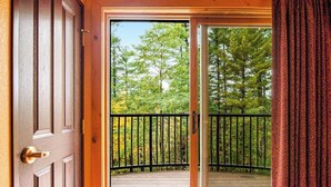 A wooden door leading to a deck with a black railing, overlooking a forested area. - Family Friendly Chula Vista Studio/Discount Perks (Wisconsin Dells)