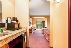 A hotel room with a kitchenette, a bed, a desk, and a view of the outdoors. - Family Friendly Chula Vista Studio/Discount Perks (Wisconsin Dells)