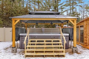 A wooden gazebo with a metal roof, a hot tub, and a wooden deck. - Inviting Dog-Friendly Cabin with Hot Tub & AC (Conover)