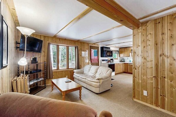 Un intérieur en bois avec un canapé, une table basse et un téléviseur.