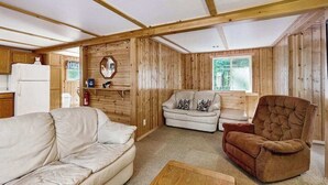 A wooden interior with a sofa, armchair, and a small table. - Dog-Friendly Retreat Near Trails & Lake with Full Kitchen, Central AC, & WiFi (Eagle River)