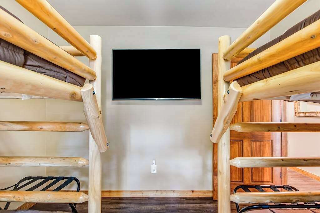 Stockbetten mit an der Wand befestigtem Fernseher.