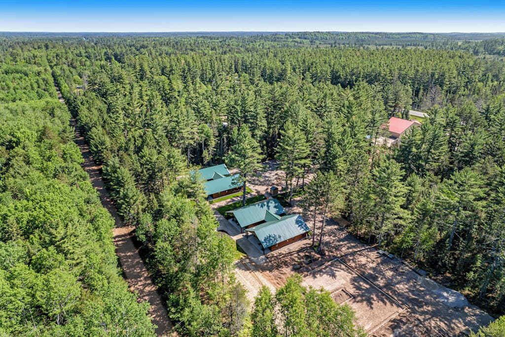 An aerial view of a forested area with several cabins.