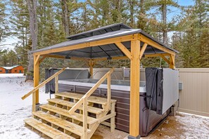 A wooden outdoor hot tub structure with a roof, wooden steps, and a covered area. - Stylish dog-friendly cabin w/hot tub, fireplace, patio, grill, central AC, & W/D (Conover)