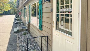 Rakennuksessa on rivi ikkunoita, ovi sekä pieni ulkoalue, jossa on portaita ja kaide.