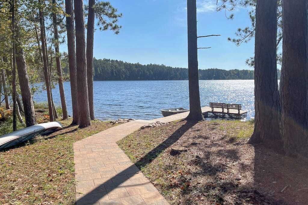 A lakeside path with a bench, trees, and a clear view of the lake.