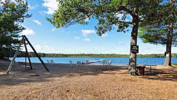 Ett område vid stranden med en gunga, picknickbord och en skylt som visar att det är privat strand.