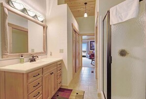 A bathroom with a sink, mirror, and towel rack.