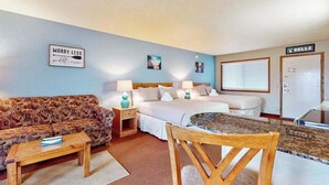 A bedroom with a bed, bedside tables, a sofa, a dining table, and a small kitchen area. - Golf-adjacent condo with balcony & arcade (Wisconsin Dells)