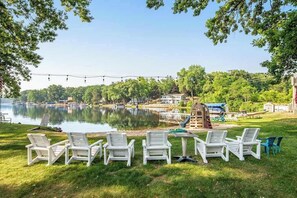 A lakeside setting with outdoor seating, a boat house, and a covered area.