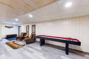 Una habitación con mesa de billar, sofá y alfombra estampada.