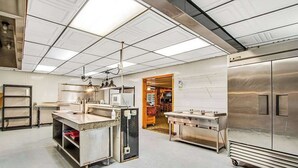 A commercial kitchen with stainless steel appliances, a central island, and overhead lighting. - Full hotel with bar, commercial kitchen, pool table & fireplaces - dog-friendly (Winchester)