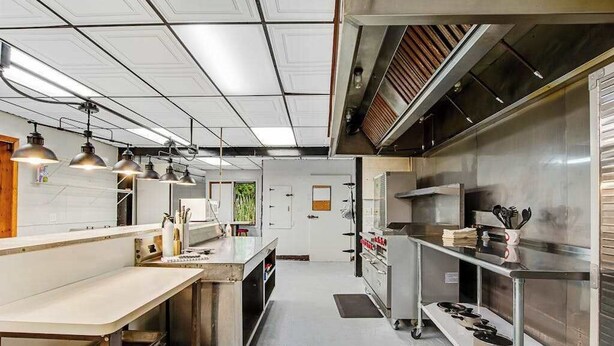 A modern kitchen with stainless steel appliances, pendant lighting, and a clean, organized layout. - Full hotel with bar, commercial kitchen, pool table & fireplaces - dog-friendly (Winchester)