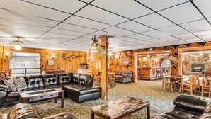 A log cabin-style interior with a fireplace, leather furniture, and wooden walls. - Full hotel with bar, commercial kitchen, pool table & fireplaces - dog-friendly (Winchester)