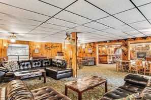 Ein rustikales Interieur im Blockhausstil mit Kamin, Ledermöbeln und Holzwänden.